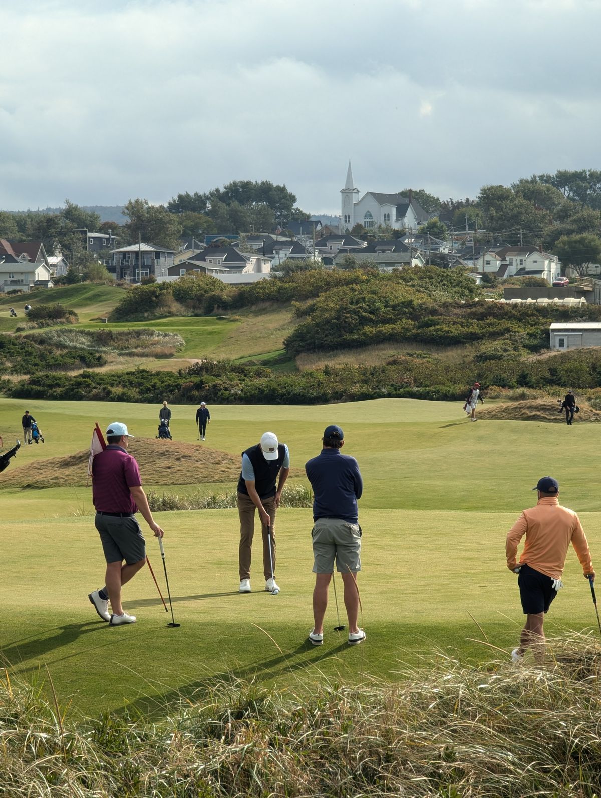 A foursome of golfers gathered together on the green