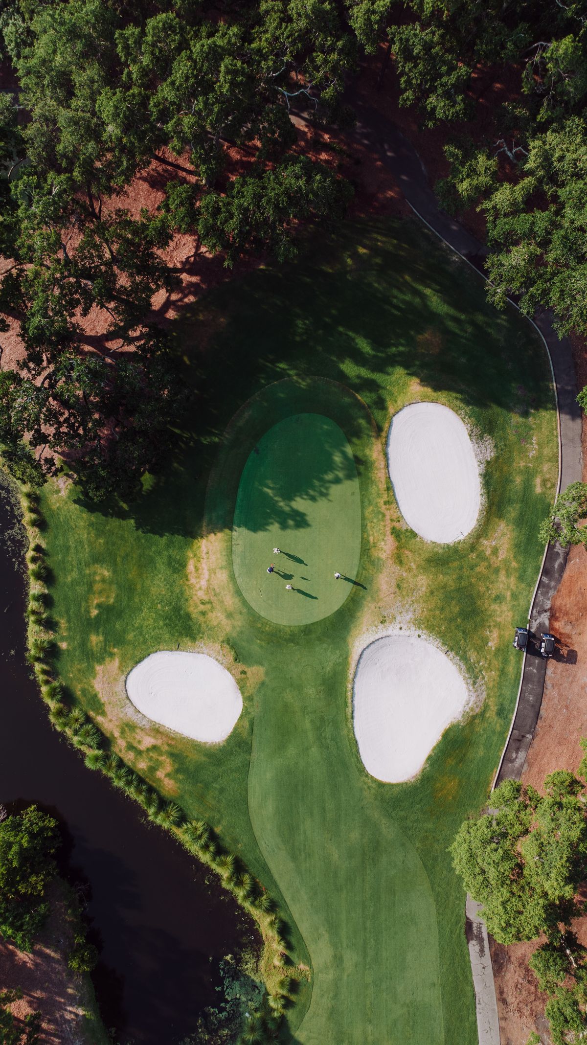 Aerial view of a golf green ringed by white sand bunkers
